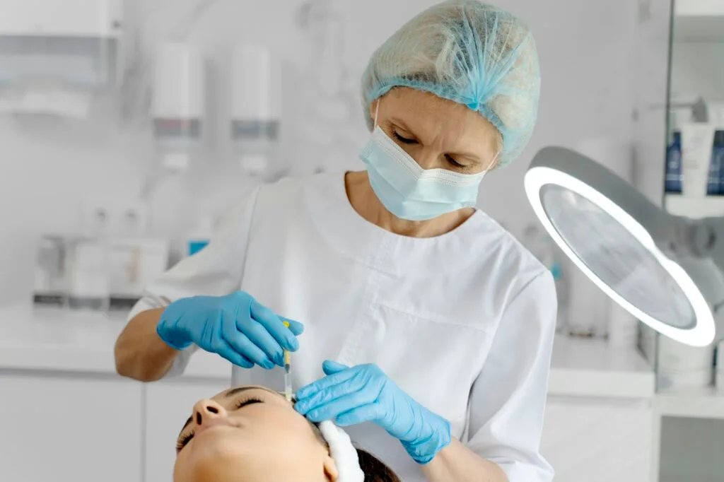 Cosmetologist does prp therapy on the face of a beautiful woman in a beauty salon