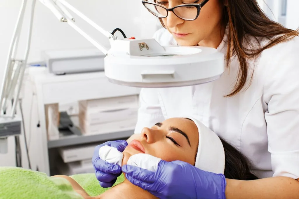 Young woman has a facial acne cleansing treatment in a beauty salon